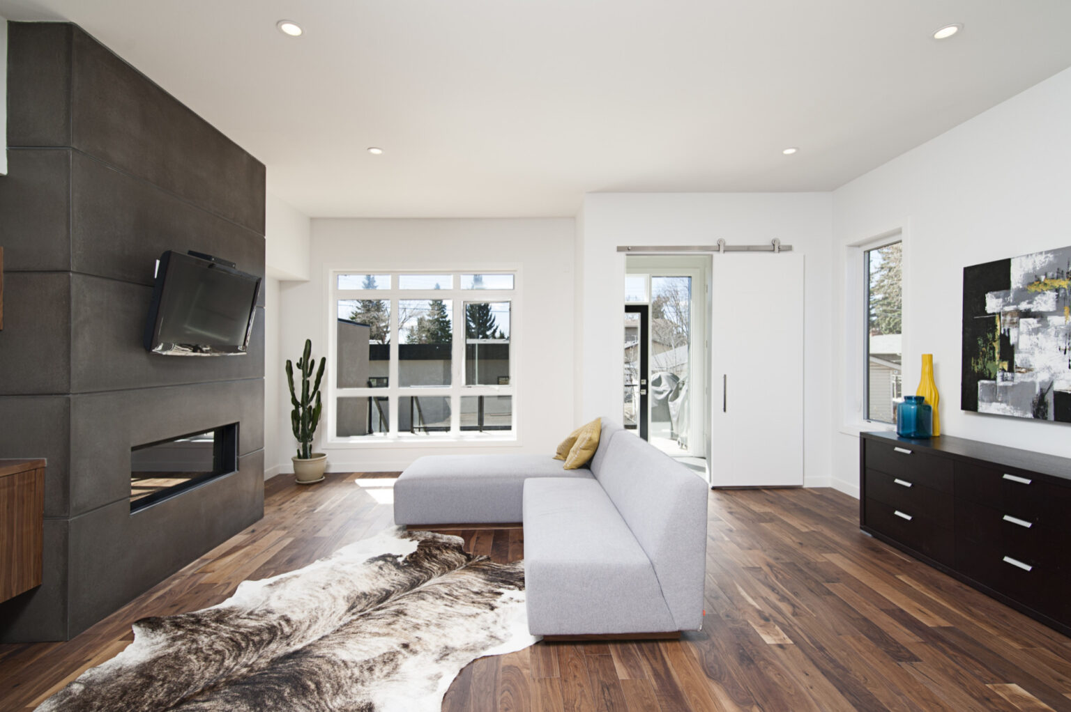 salón amplio con suelo de madera tras reforma integral en vivienda de Barcelona