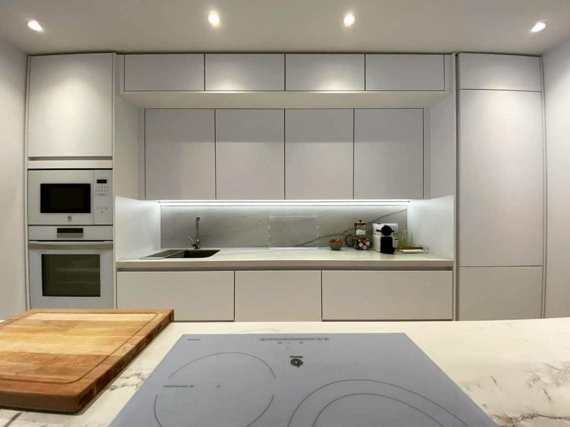 cocina blanca moderna con iluminación LED tras reforma en Barcelona